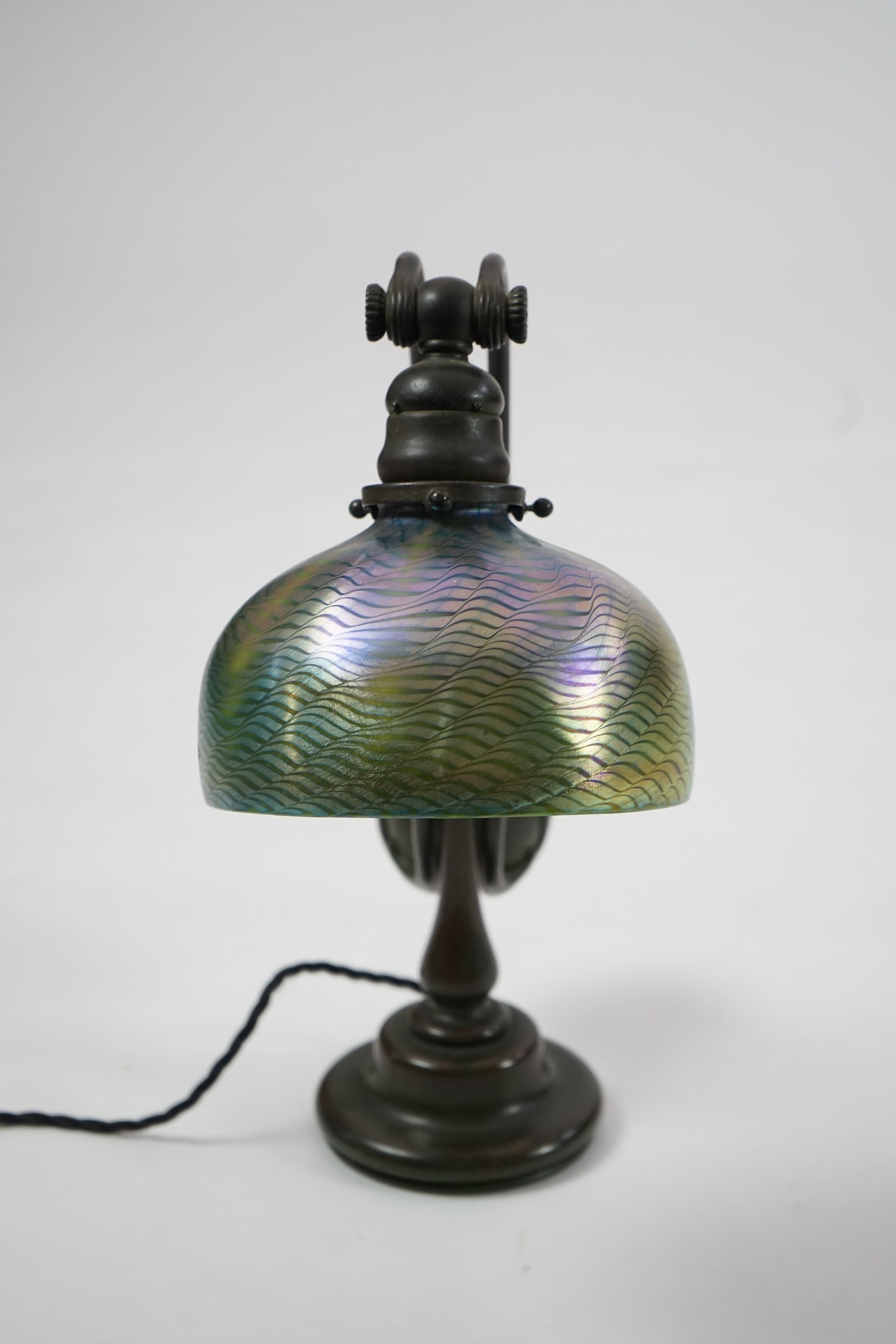 Tiffany Studios. A patinated bronze counter-balance desk lamp with ‘favrile’ glass shade, c.1905